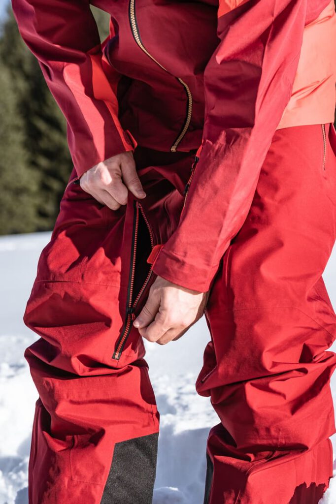 Person öffnet die Beinbelüftung der Skihose