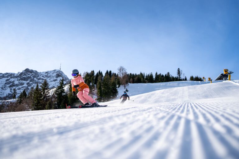 Zwei Skifahrer fahren auf einer leeren Piste in St. Johann - Chris Gollhofer Snow Card Tirol Skifahren Sportfotograf