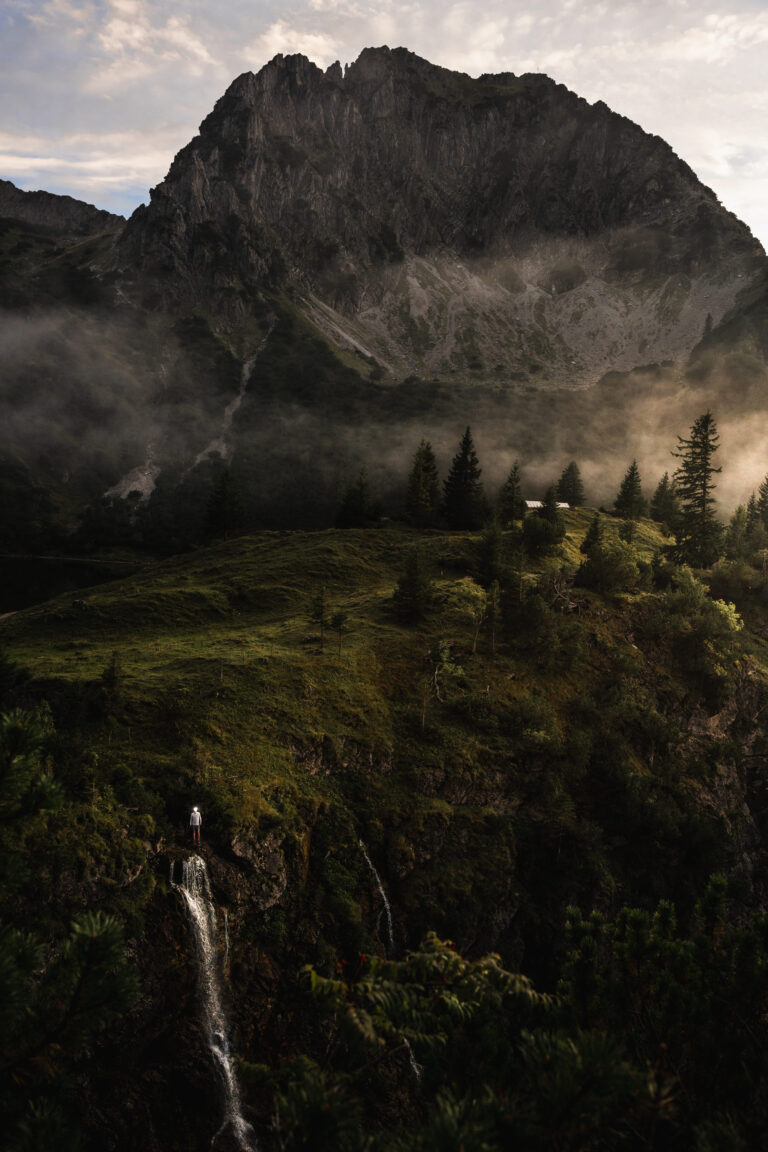 Ein Mann steht an einem Wasserfall in den Bergen - Chris Gollhofer Lifestylefotograf - Bayern